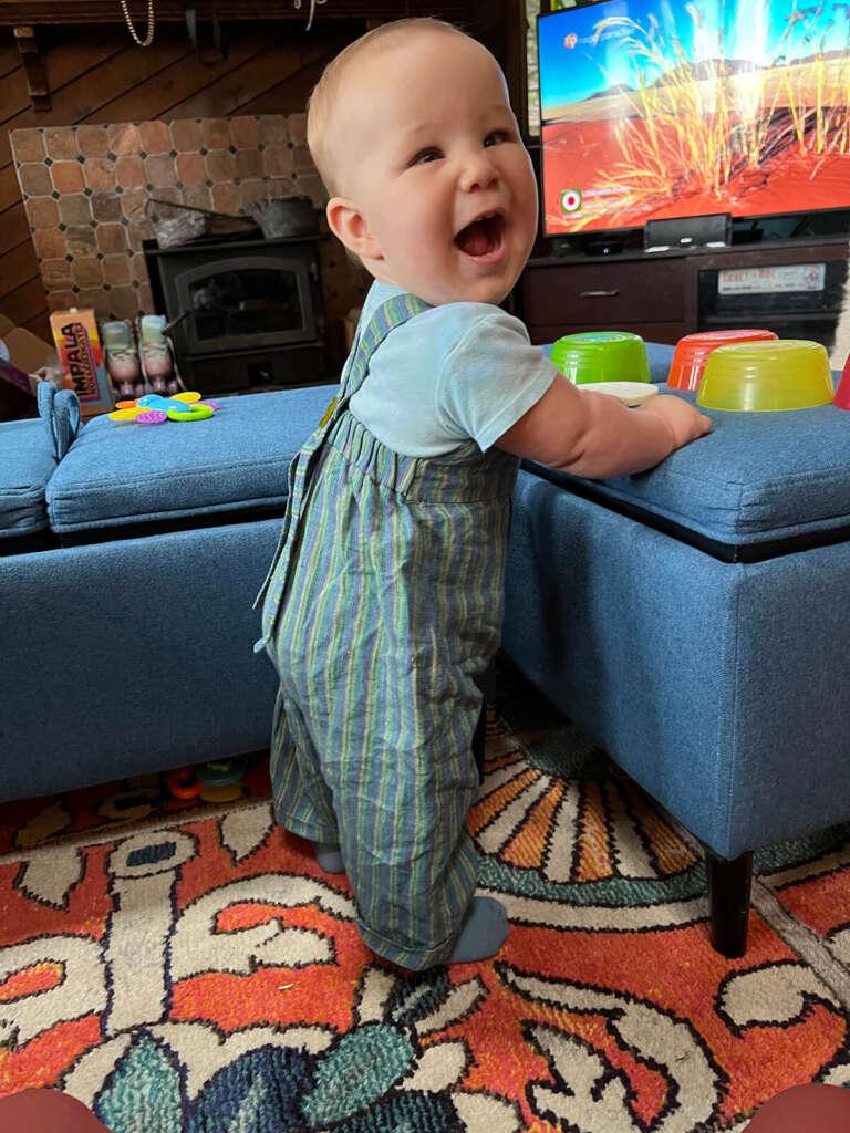 Birdie wearing striped linen overalls