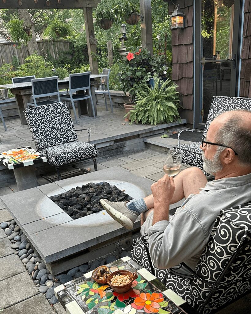 brian blevins sitting out on his patio, enjoying a glass of rose wine, some olives and the new mosaic tile tables