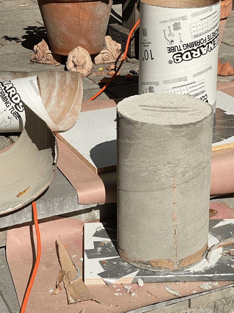 cardboard concrete form peeled off to reveal finished concrete cylinder base for mosaic tile tabletop