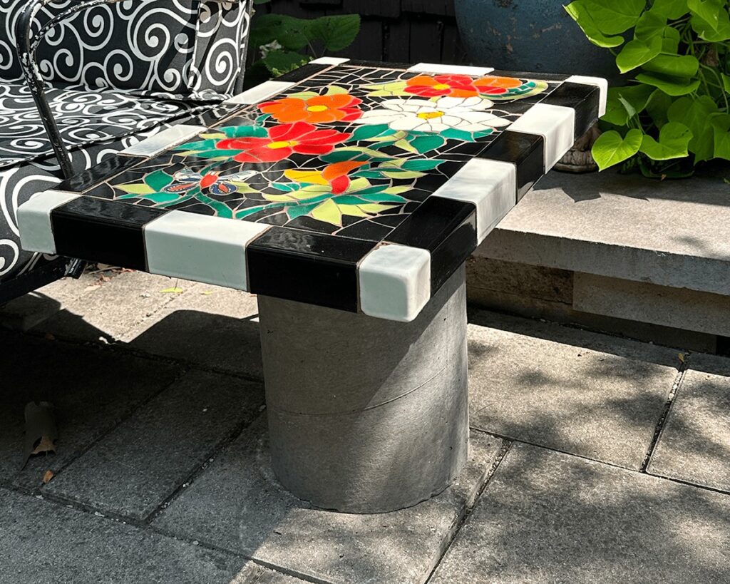 trencadis broken tile mosaic tile tabletop mounted to concrete base in position on the patio